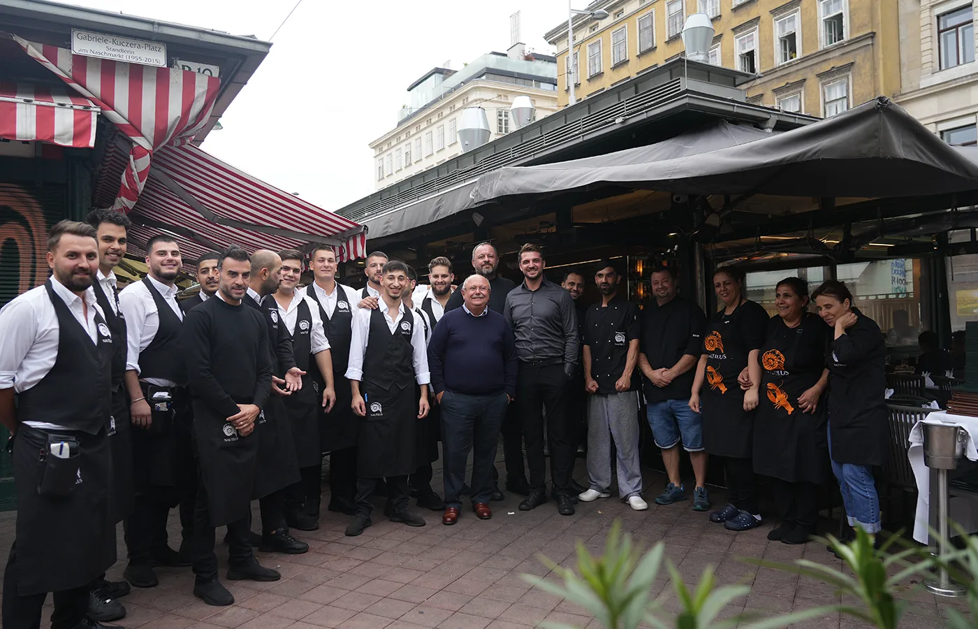 The team of Nautilus fish restaurant in front of the restaurant at Vienna's Naschmarkt